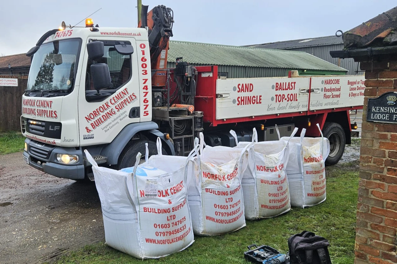 Norfolk Cement delivery lorry unloading bulk bags of building materials at a customer property